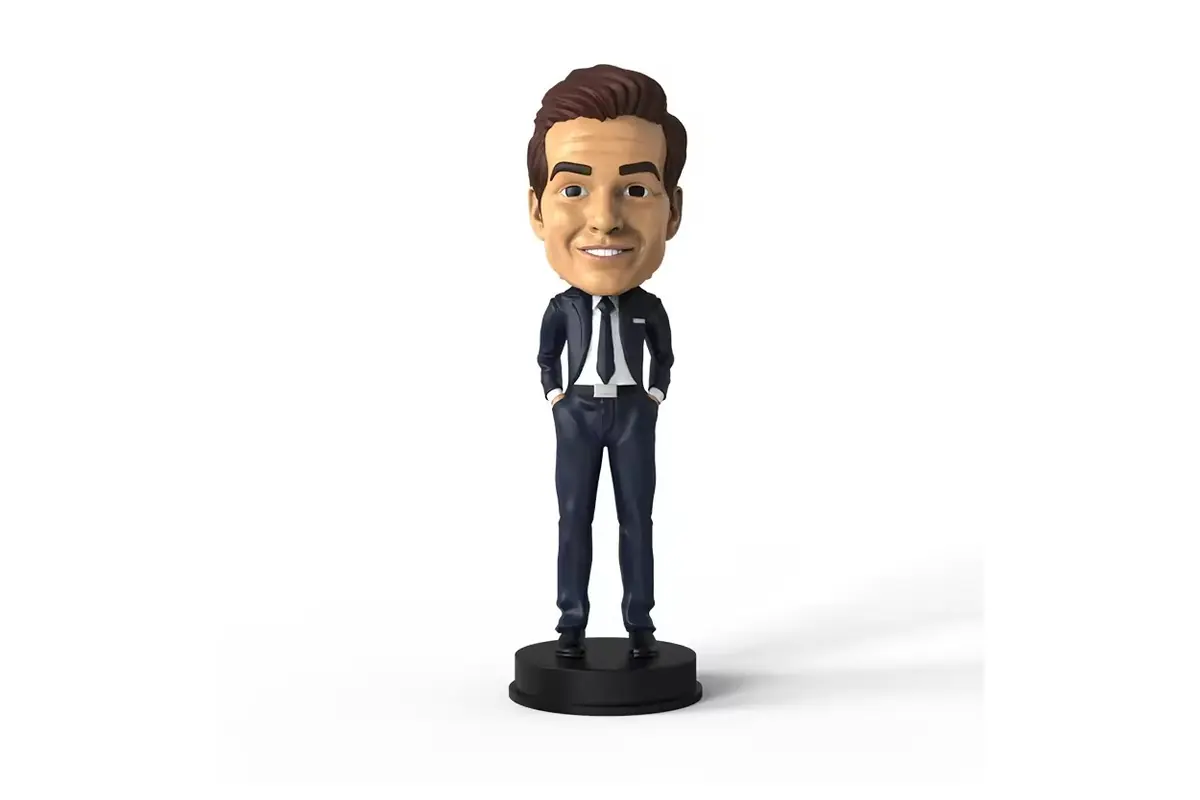 Smiling businessman bobblehead in a dark suit on a black base