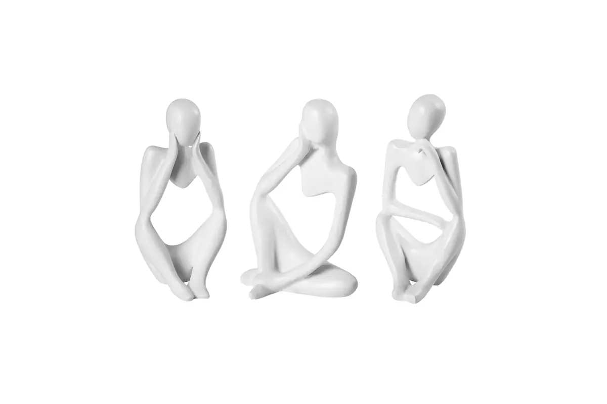 Three white abstract seated figurines with smooth sculpted surfaces