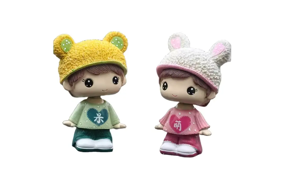 Two colorful character bobbleheads wearing knitted-style animal hats