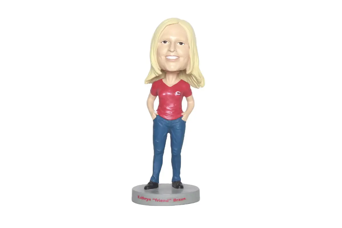 A long-haired woman bobblehead in a red top on a round base