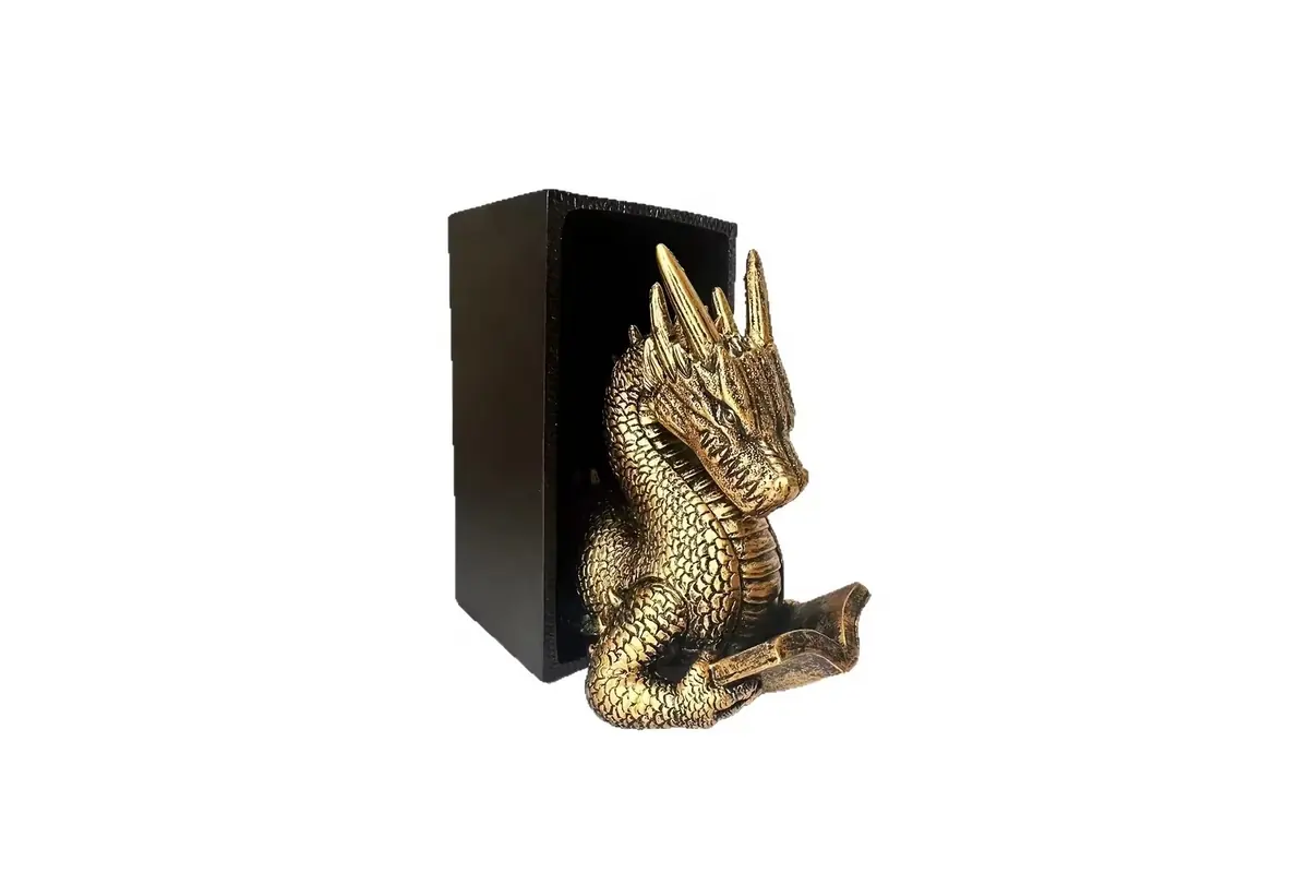 A gold-colored dragon sculpture against a black bookend support