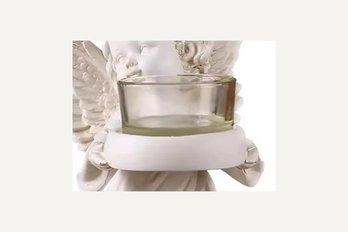 Close view of the empty glass cup held by an ivory angel figure