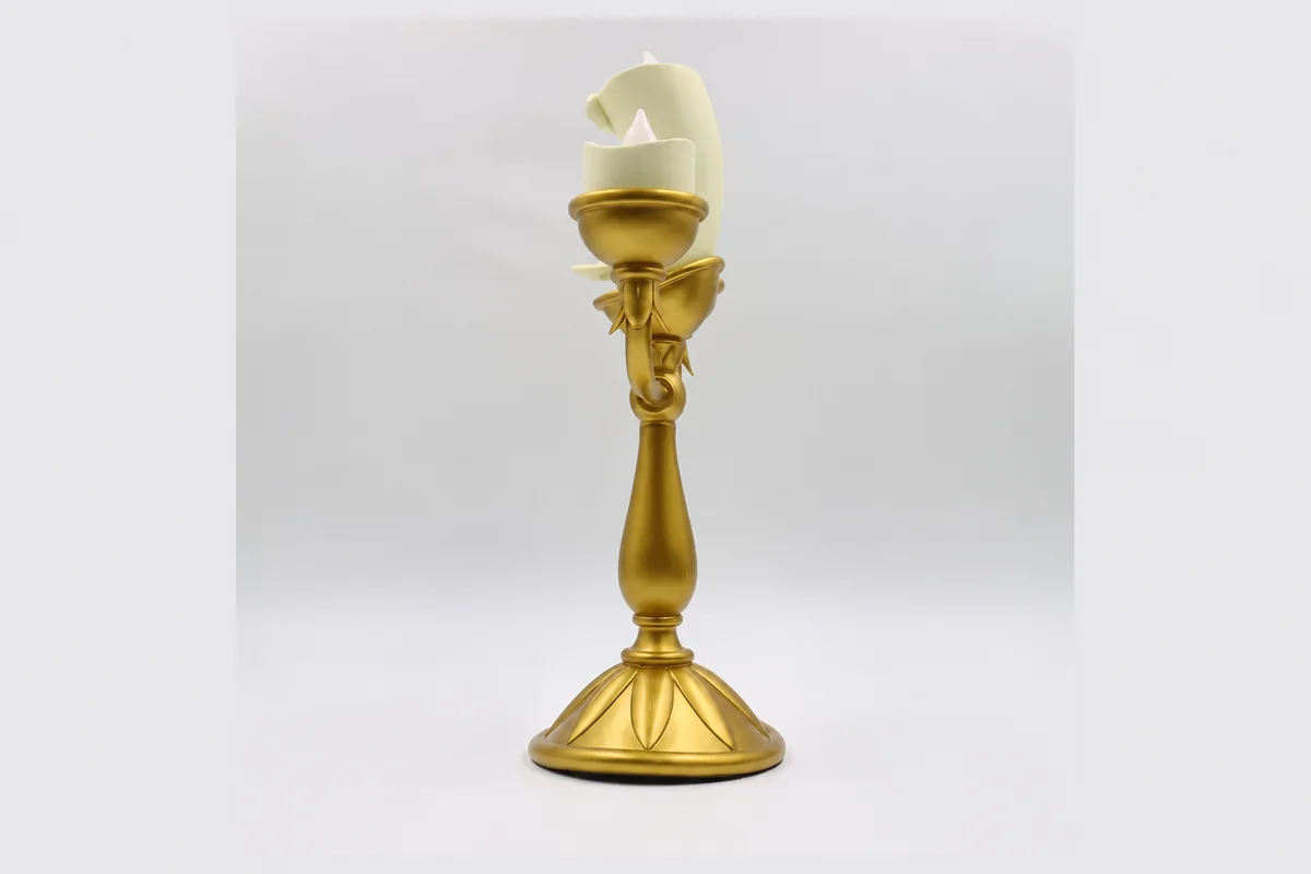 A single gold-colored candlestick with an upright cup and circular base