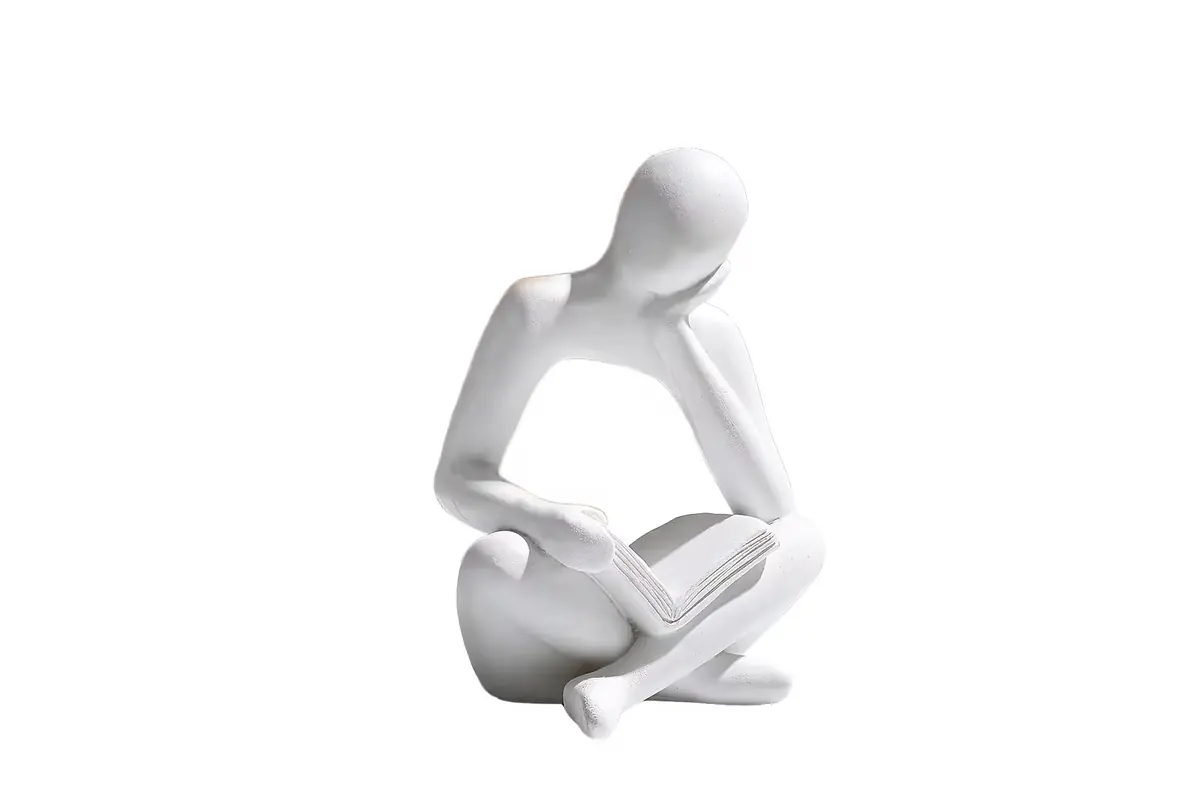 A white abstract seated figure holding an open book