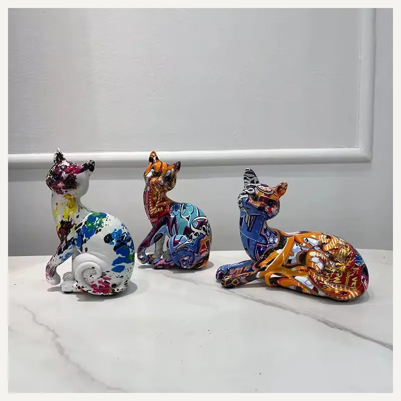 Colorfully patterned cat figurines on a marble tabletop