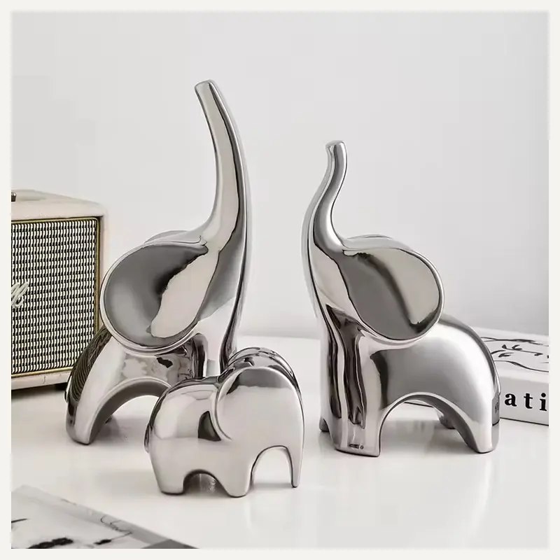 Reflective silver-colored elephant figurines with raised trunks