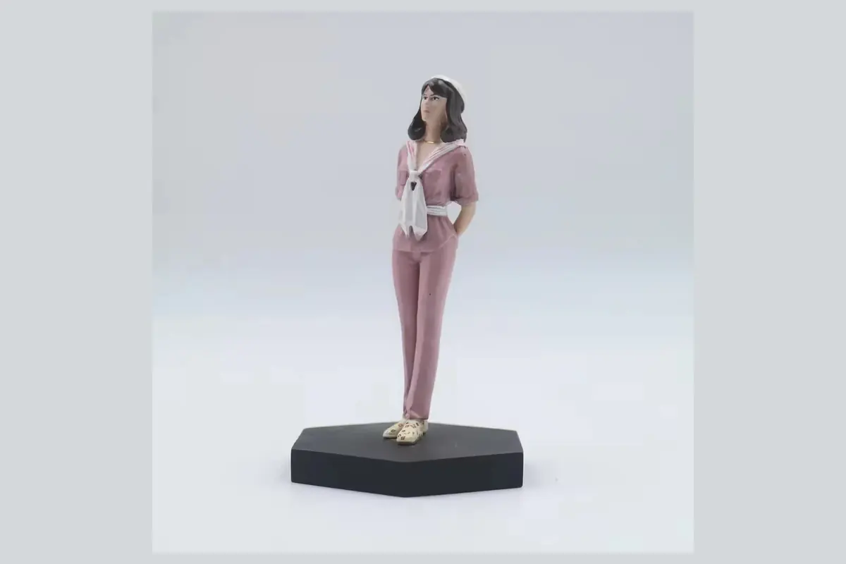 A standing woman figurine on a rectangular black display plinth