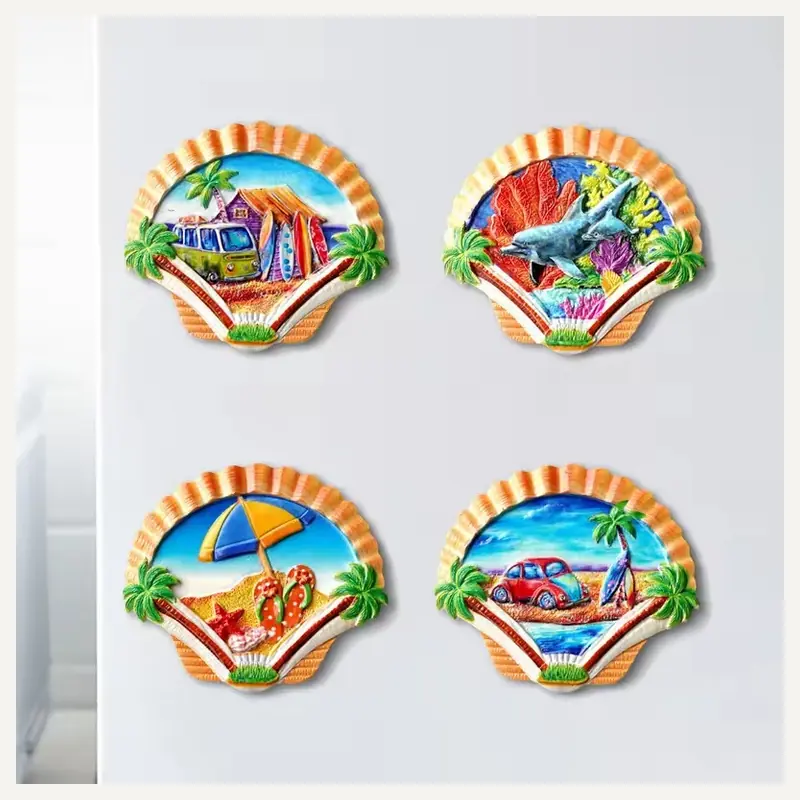 Four seashell-shaped souvenir magnets with miniature coastal scenes