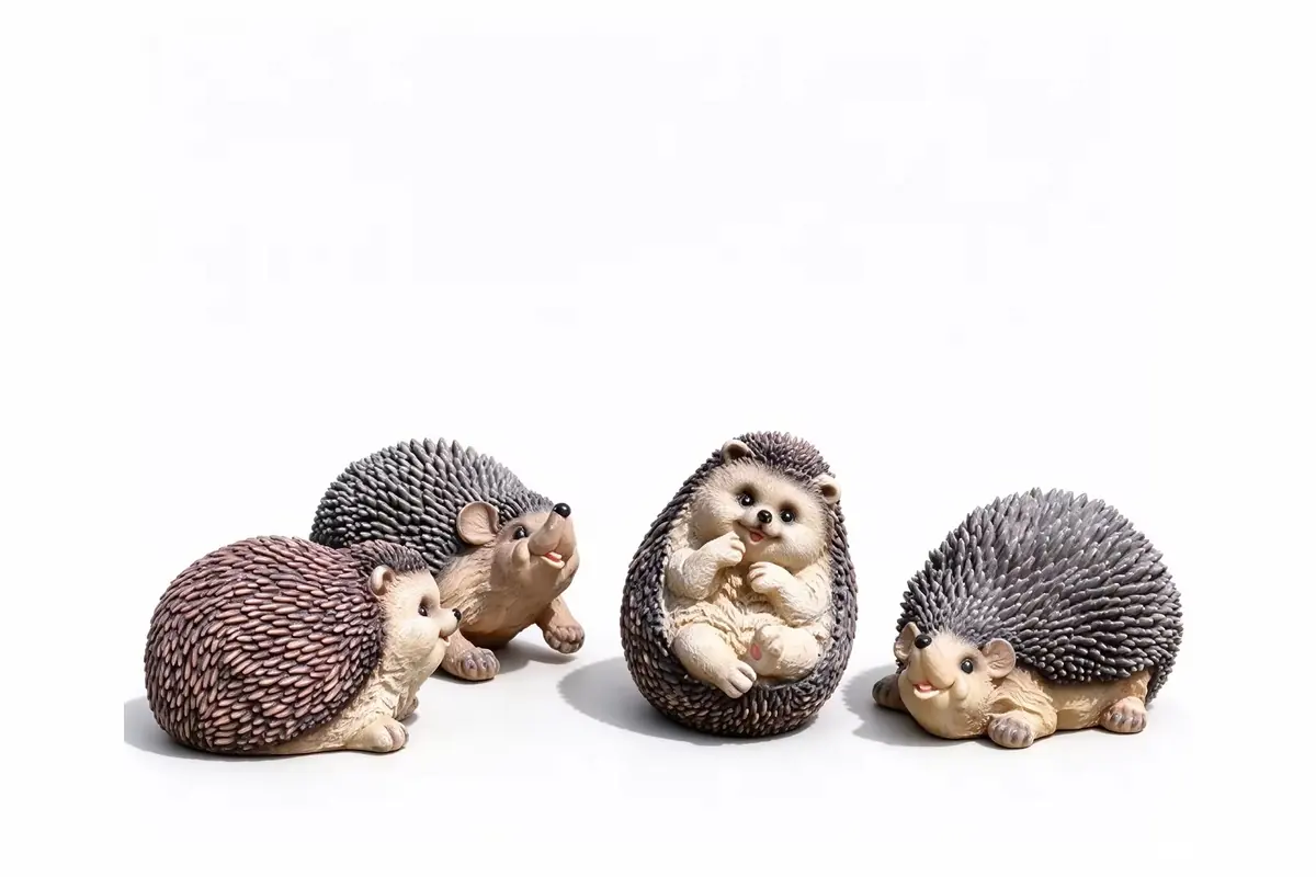 Four hedgehog garden figurines in different compact poses