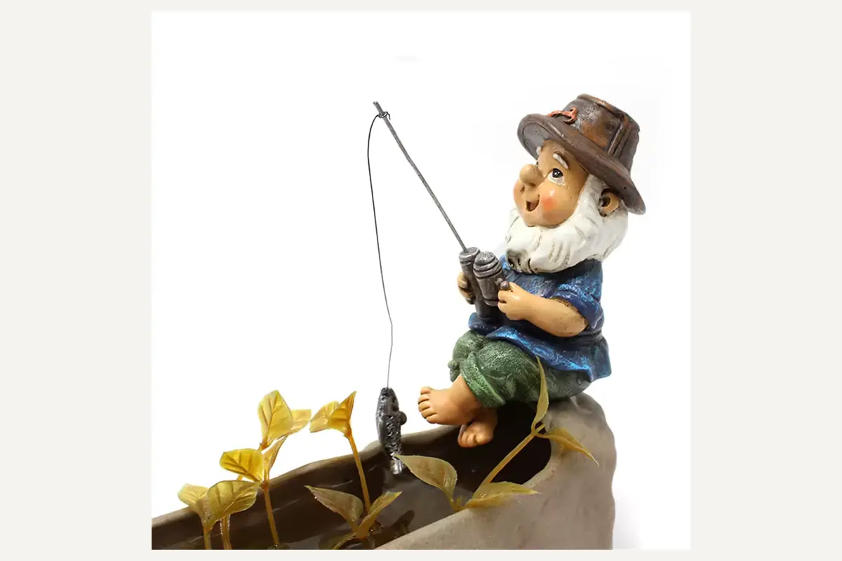 A fishing gnome figure with a boat, rod and sculpted accessories