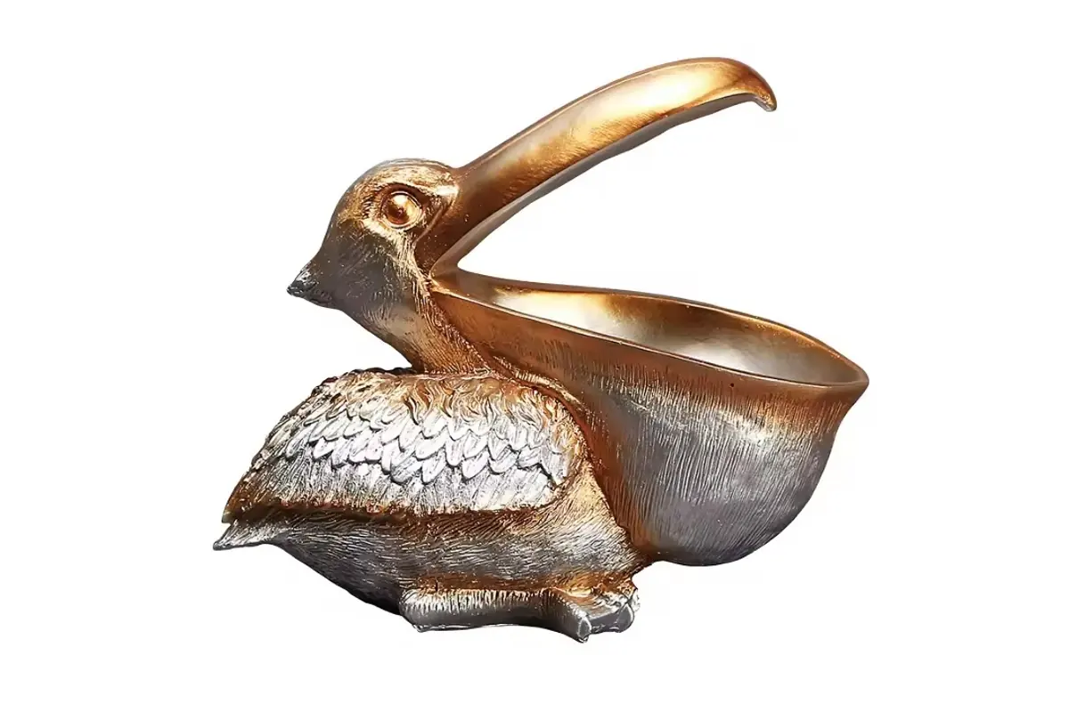 A pelican garden sculpture with a gold-colored metallic-look finish