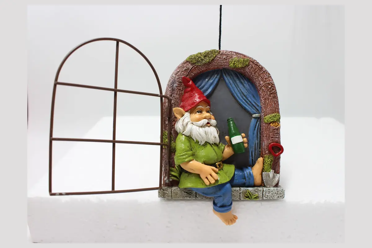 A garden gnome window decoration with an open frame and hanging cord