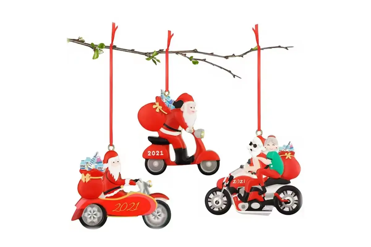 Three red Santa and snowman hanging ornaments on holiday branches