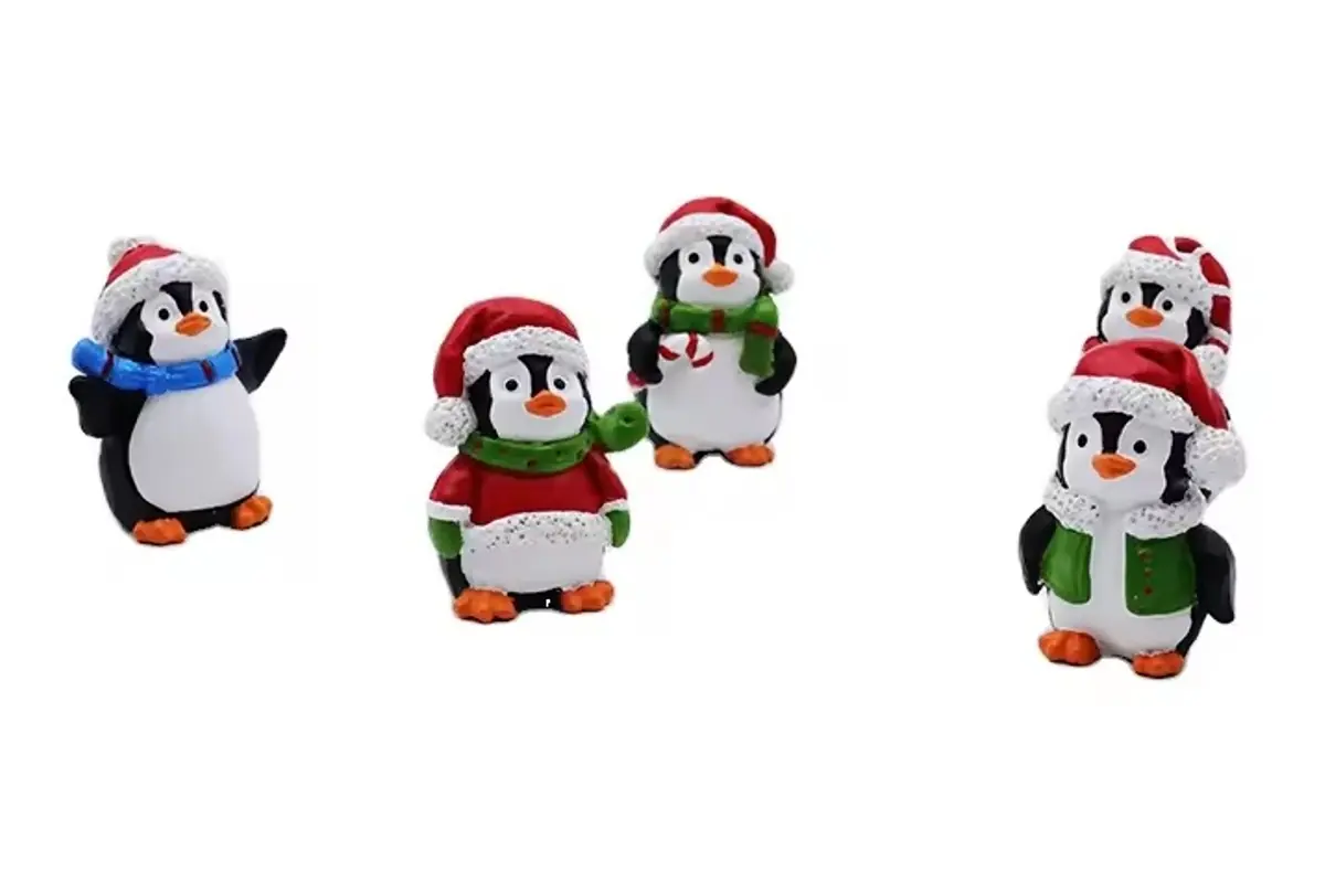 Five small penguin ornaments wearing colorful winter hats and scarves