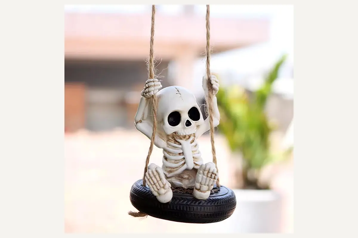 A skeleton character hanging from a small black swing