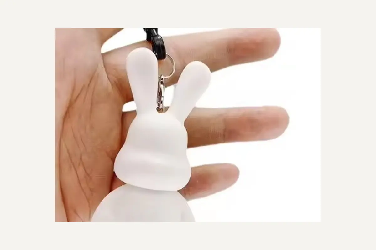 The top loop and strap on an unpainted rabbit-shaped keychain