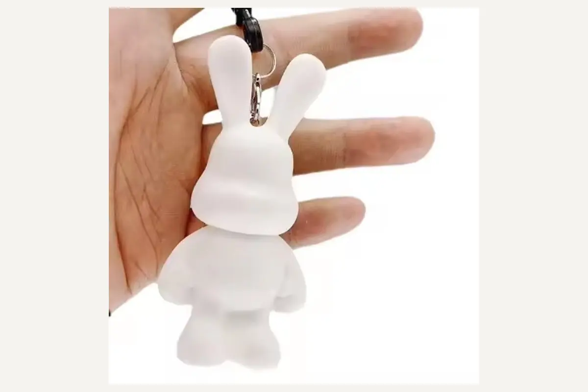 Unpainted white rabbit-shaped keychain held in a hand