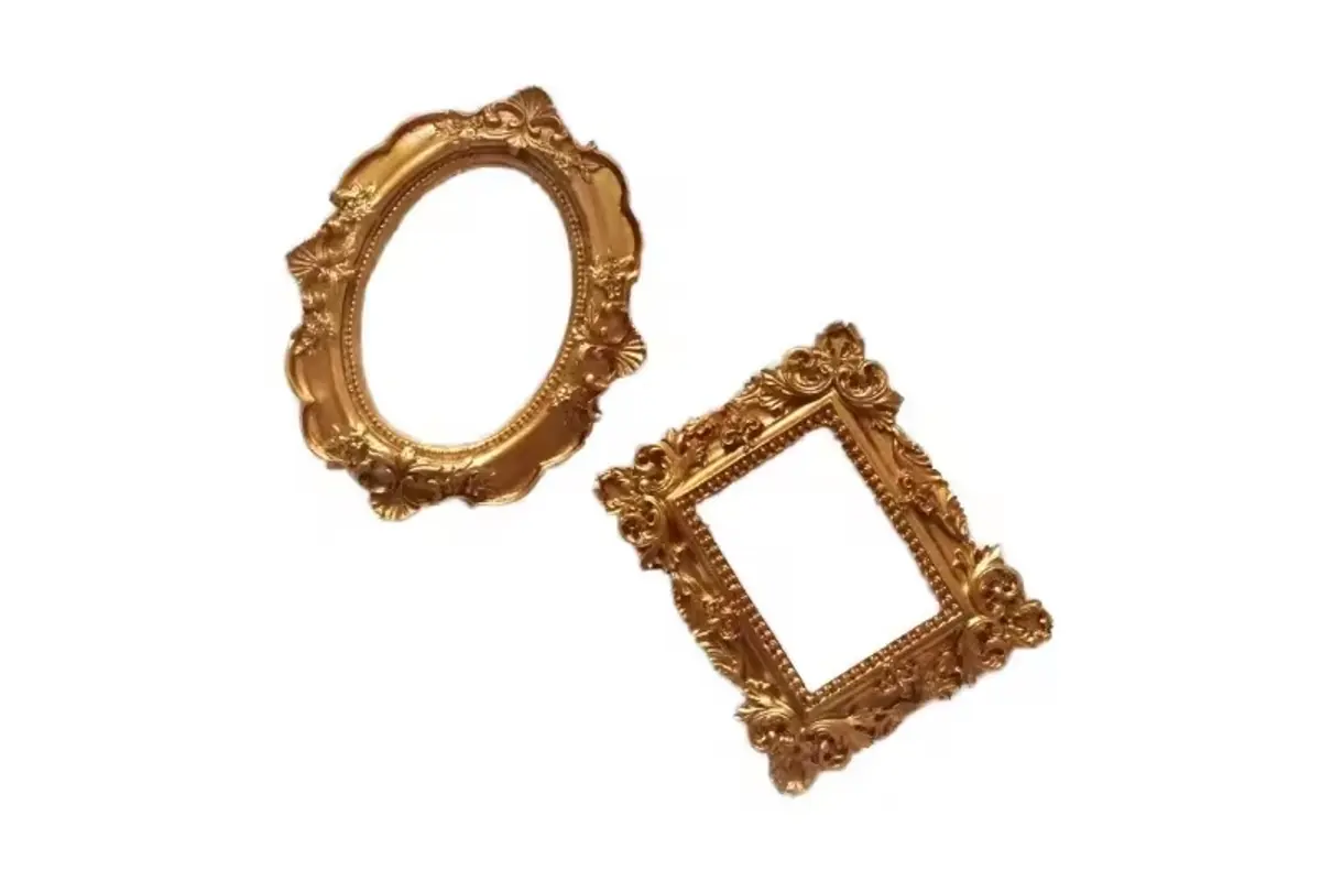 Two empty gold-colored frame surrounds in oval and rectangular shapes