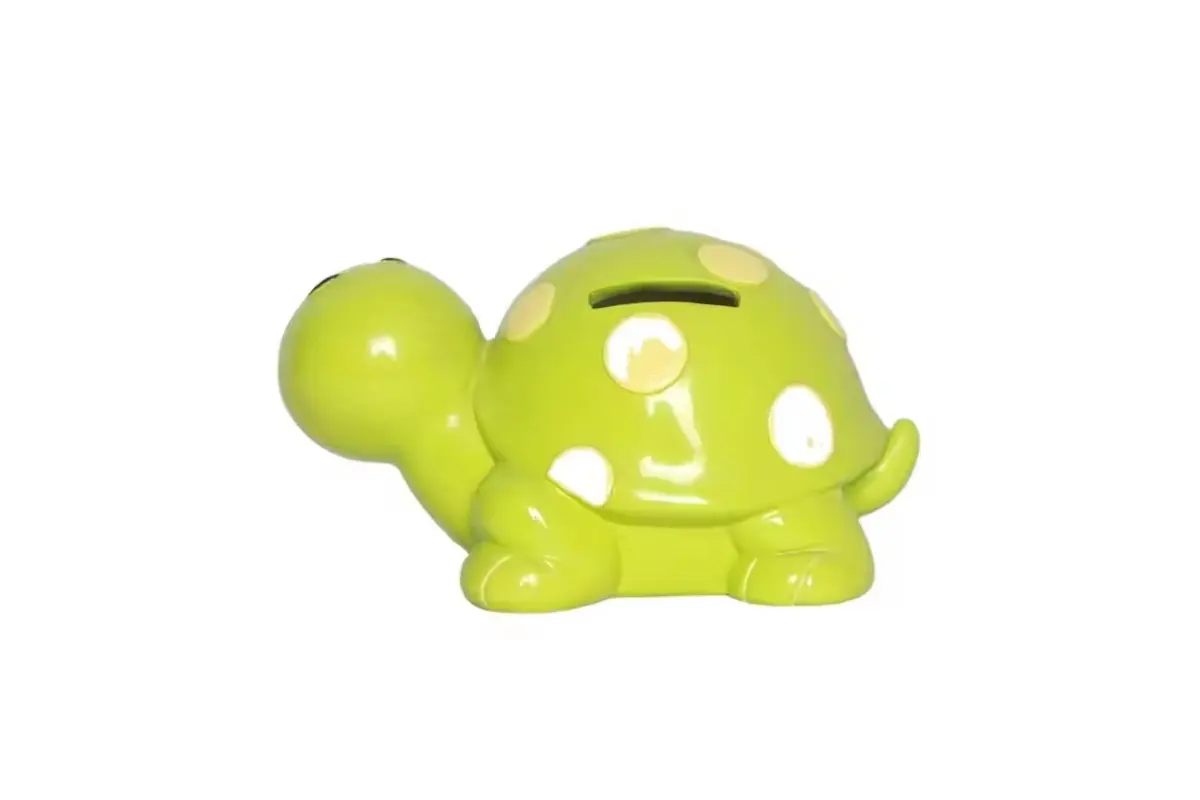 A green turtle-shaped coin bank with a visible slot on its shell