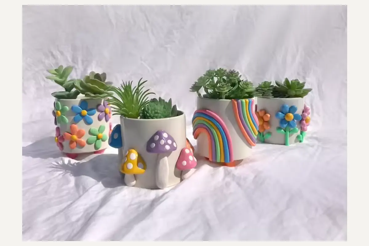 A group of small planters decorated with raised flowers, mushrooms and rainbows