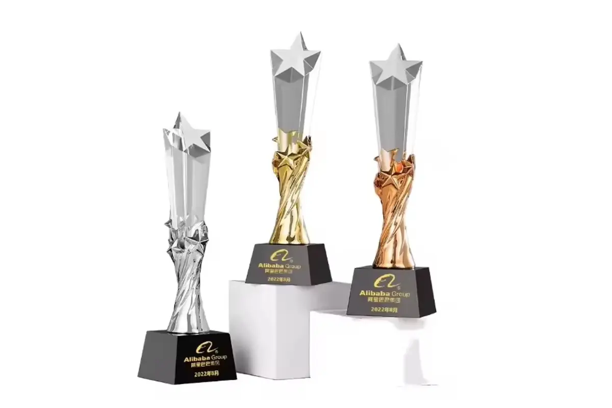 Three star-topped awards with gold-, silver- and bronze-colored figures